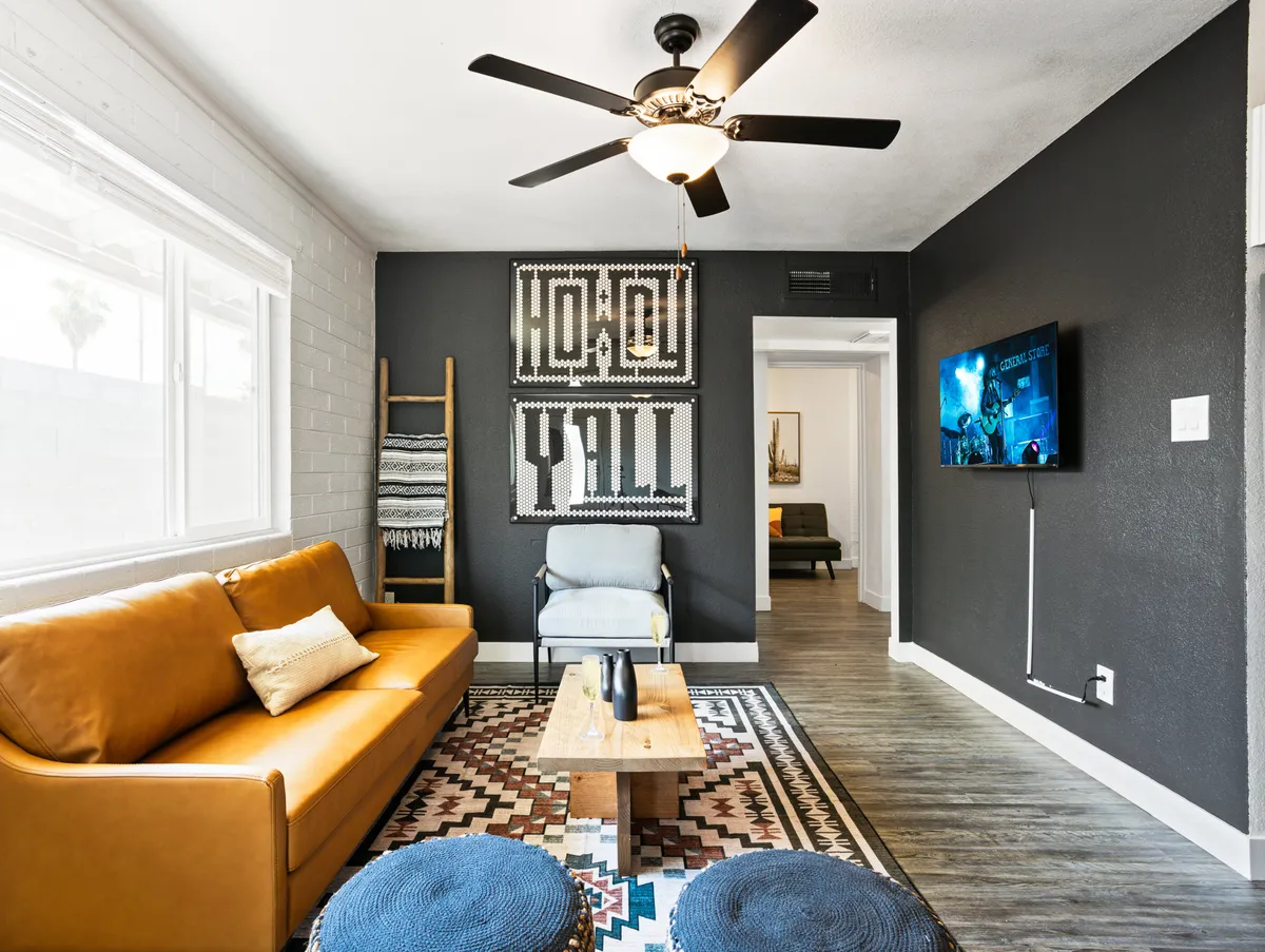 A welcoming living area centered around a leather sofa, decorative wall art, a wooden coffee table, and a Smart TV. The room exudes comfort and is clearly set up for both socializing and entertainment, ideal for movie nights or casual hangouts.